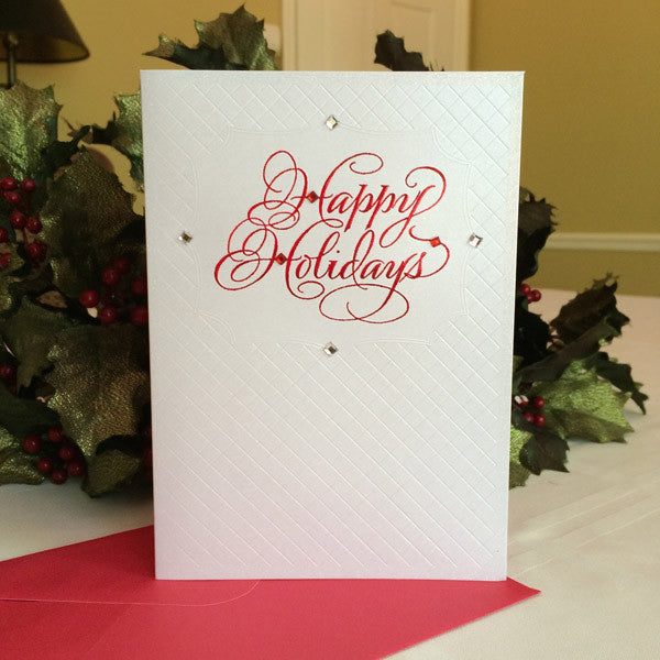 Happy Holidays card with red lettering by calligrapher Holly Monroe and publisher DesignDesign